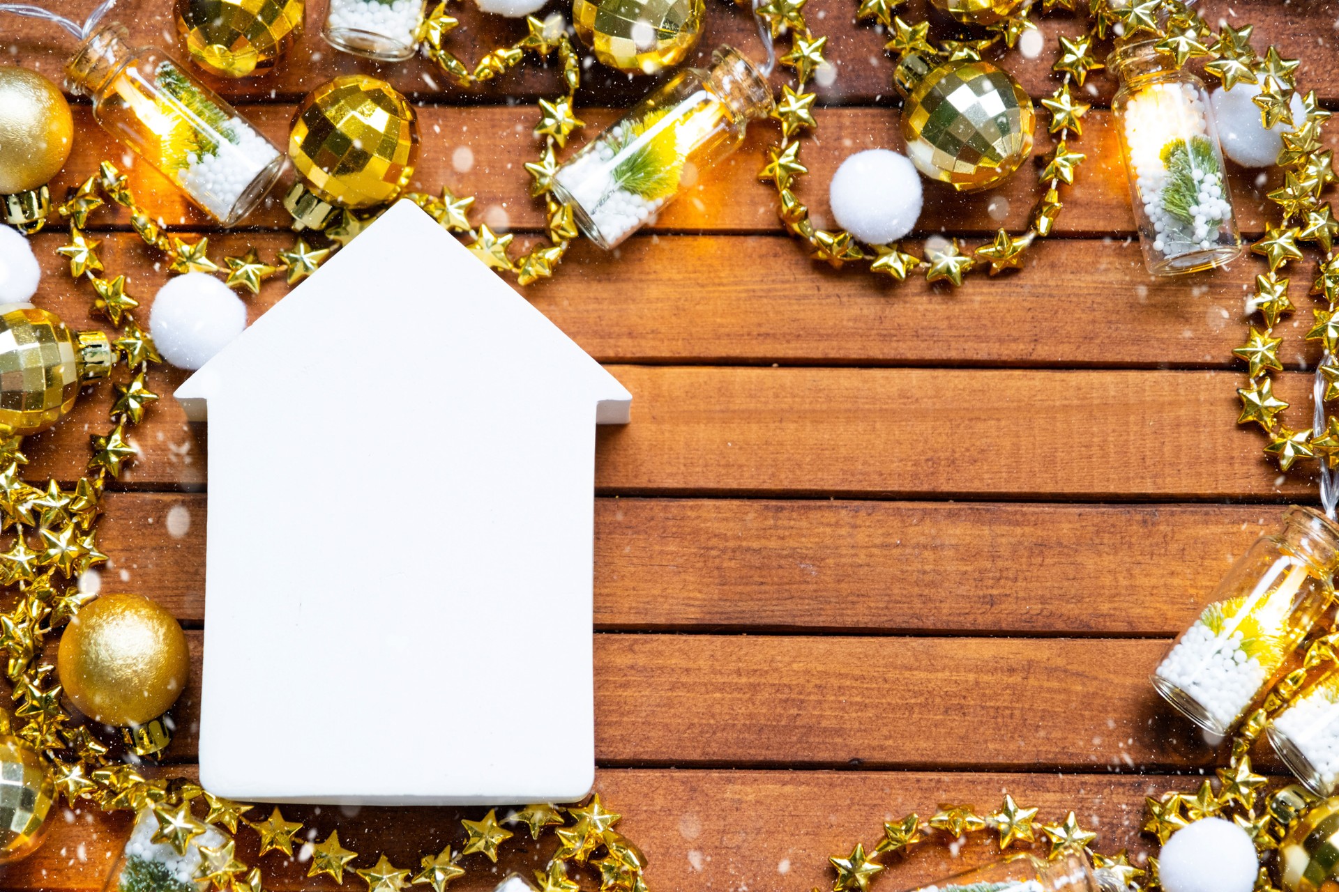 Tiny white house mock up on wooden background with Christmas decor layout and copy space. Gift for New Year, Christmas. Building, project, moving to new house, mortgage, rent and purchase real estate